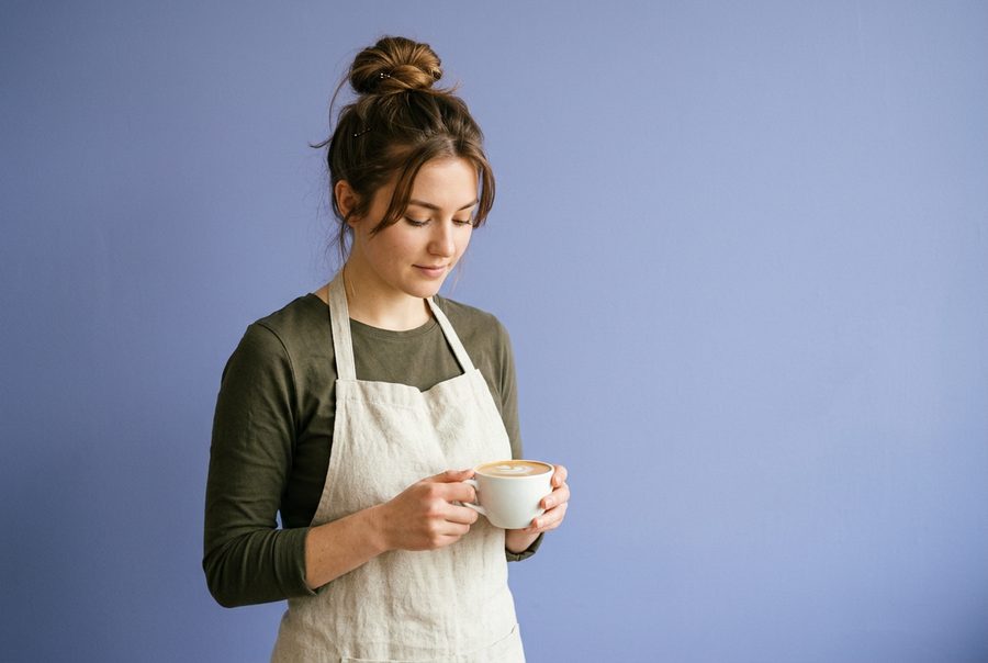 A barista holding a cup of coffee